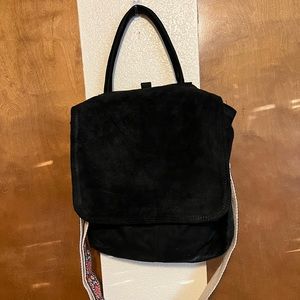 A black suede satchel. Has a guitar like strap that is adjustable.